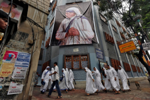 Nuns belonging to the global Missionaries of Charity, walk past a large banner of Mother Teresa ahead of her canonisation ceremony, in Kolkata, India September 3, 2016.  <br/>REUTERS/Rupak De Chowdhuri