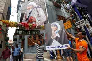 A man holds a poster of Mother Teresa outside the Missionaries of Charity building in Kolkata as she was canonised during a ceremony held in the Vatican, India September 4, 2016.  <br/>REUTERS/Rupak De Chowdhuri