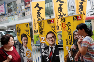 People walk past banners of Erica Yuen, Christopher Lau candidates from People Power and 