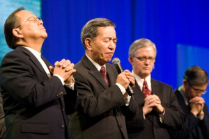 (l-r) Morley Lee, general secretary of The Chinese Coordinating Center of World Evangelization; Philemon Choi, honorary general secretary of Breakthrough ministry in Hong Kong; and Doug Birdsall, executive chair of The Lausanne Movement pray for the church in China at Lausanne III on Monday, October 18, 2010, in Cape Town, South Africa. <br/>The Christian Post/Hudson Tsuei