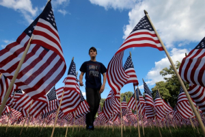Jackson Tucker walks through the field  of 3,000 U.S. flags placed in memory of the lives lost in the September 11, 2001 attacks, at a park in Winnetka, Illinois, September 10, 2016. REUTERS/Jim Young <br/>