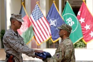 U.S. soldiers hand over the flag during a memorial ceremony to commemorate the 15th anniversary of the 9/11 attacks, in Kabul, Afghanistan September 11, 2016. REUTERS/Omar Sobhani <br/>