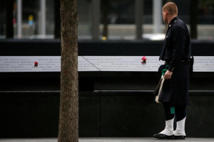 A member of the New York Police Department's (NYPD) Emerald Society Pipe & Drum Band looks at memorial before the start of the ceremony marking the 15th anniversary of the attacks on the World Trade Center, at The National September 11 Memorial and Museum in Lower Manhattan in New York City, U.S. September 11, 2016.  REUTERS/Brendan McDermid <br/>