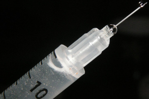 Photo showing close-up of a medical syringe and needle on a black background <br/>Wikimedia Commons