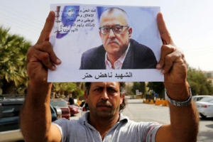 A relative of the Jordanian writer Nahed Hattar holds his picture during a sit-in in the town of Al-Fuheis near Amman, Jordan, 25 September 2016 <br/>Reuters