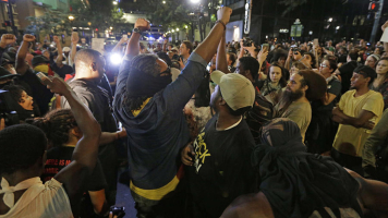 Protesters shout as they march downtown on the third night of protests in Charlotte, N.C. Thursday, Sept. 22, 2016, following Tuesday's fatal police shooting of Keith Lamont Scott in Charlotte, N.C. <br/>Chuck Burton / AP