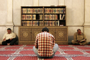 Men reading the Koran in between two prayer times in Umayyad Mosque, Damascus, Syria. <br/>Wikimedia Commons
