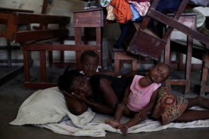 A woman with two of her children rest on the floor at the shelter set up in the Lycee Philippe Guerrier ahead of Hurricane Matthew in Les Cayes, Haiti, October 3, 2016.  <br/>REUTERS/Andres Martinez Casares