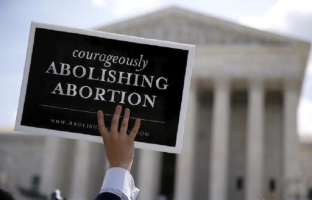 Anti-abortion protestors celebrate the U.S. Supreme Court's ruling striking down a Massachusetts law that mandated a protective buffer zone around abortion clinics, outside the Supreme Court in Washington June 26, 2014. <br/>Reuters/Jim Bourg