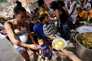 Children queue as they wait to receive free food which was prepared by residents and volunteers on a street in the low-income neighborhood of Caucaguita in Caracas, Venezuela. <br/>Reuters/Henry Romero