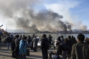South Koreans watch smoke raising from South Korea's Yeonpyeong island near the border against North Korea Tuesday, Nov. 23, 2010. North Korea fired artillery barrages onto the South Korean island near their disputed border Tuesday, setting buildings alight and prompting South Korea to return fire and scramble fighter jets. <br/>AP Images / Yonhap