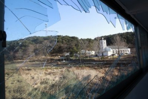 A cathedral is seen through a window destroyed in Tuesday's attack on Yeonpyeong Island, South Korea, Sunday, Nov. 28, 2010. The United States and South Korea began joint war games Sunday as a top official from North Korea's closest ally met South Korea's president in a bid to calm tensions after the deadly North Korean artillery attack. <br/>AP Images / Lee Jin-man