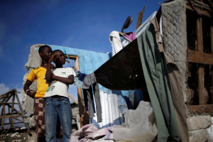 Boys stand next to their destroyed home after Hurricane Matthew hit Jeremie, Haiti, October 13, 2016.  <br/>REUTERS/Carlos Garcia Rawlins