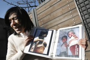 Korean-American missionary Robert Park with photos of North Korean children suffering from famine prays during a press conference in front of the Chinese Cosulate in Seoul, South Korea, Friday, Dec. 3, 2010. Park released following 43 days of captivity for illegally crossing into North Korea said Wednesday that he had been tortured in the communist country. <br/>AP/Ahn Young-joon