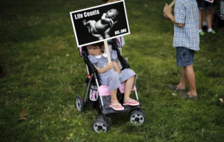 A girl holds a sign as she attends a 
