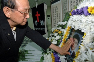 A South Korean relative touches a picture of slain pastor Bae Hyung-kyu who was among the 23 South Koreans kidnapped in Afghanistan, in Jeju, south of Seoul, South Korea, Friday, July 27, 2007. <br/>(Photo/ Yonhap, Kim Ho-chun)