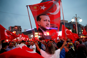A supporter holds a flag depicting Turkish President Tayyip Erdogan during a pro-government demonstration in Ankara, Turkey. Over the last months of 2016, Erdogan has extended his massive crackdown on perceived opponents to American pastors who are in Turkey, assisting refugees. <br/>Reuters / Baz Ratner
