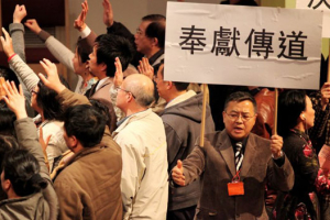 In this picture, crowds of people came towards the stage during altar calls and a man holding up a sign calling believers to dedicate their lives for missions. <br/>Rev. Zhiming Yuan's Blog. 