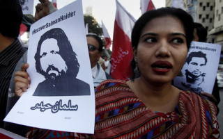 An activist holds up a photo of Samar Abbas, president of the Civil Progressive Alliance of Pakistan (CPAP), who mysteriously disappeared last week. <br/>AP Photo