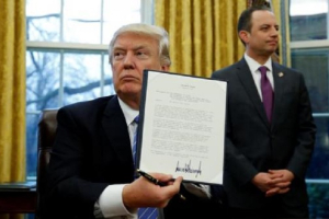 U.S. President Donald Trump holds up his executive order on the reinstatement of the Mexico City Policy after signing it in the Oval Office of the White House in Washington January 23, 2017.  <br/>Reuters/Kevin Lamarque
