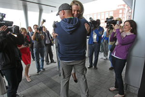 Boston Firefighter Mike Materia lifts up Roseann Sdoia to hug her after a press conference. <br/>AP photo