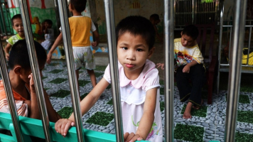A young girl looks at visitors inside a state-run orphanage in Ba Vi district, in the outskirts of Hanoi.  <br/>AFP