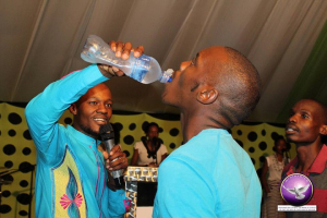 Pastor Light Monyeki of Grace Living Hope Ministries holds up the bottle of water mixed with rat poison as a church member drinks from it. <br/>Facebook/Grace Living Hope Ministries
