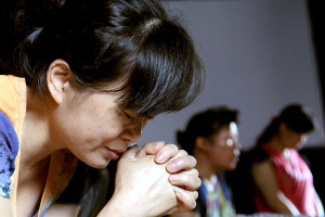 A church member prays at Jiu'en Tang, a Christian church in Wenzhou in eastern China's Zhejiang Province. <br/>Reuters