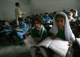 Female students Shaista (R), 12, and Rabia (L), 10, read aloud while taking part in class in Buner district about 220 km (137 miles) by road from Pakistan's capital Islamabad on August 10, 2009.  <br/>Reuters/Faisal Mahmood