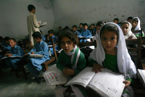 Female students Shaista (R), 12, and Rabia (L), 10, read aloud while taking part in class in Buner district about 220 km (137 miles) by road from Pakistan's capital Islamabad on August 10, 2009.  <br/>Reuters/Faisal Mahmood