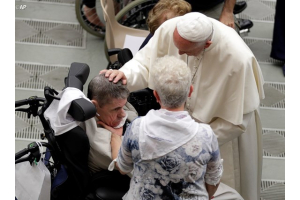 Pope Francis caresses a man during an audience with Huntington's disease sufferers and their families. <br/>Vatican Radio 