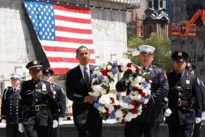 U.S. President Barack Obama carries a wreath accompanied by New York City firefighters and NYPD police officers during a wreath laying ceremony at the National September 11th Memorial at the World Trade Center site in New York, May 5, 2011. Days after the killing of Osama bin Laden, Obama met New York firefighters on Thursday before a visit to Ground Zero to offer comfort to a city still scarred by the Sept. 11 attacks. <br/>Reuters / Brendan McDermid