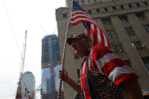A man carries the American flag outside the World Trade Center site in New York, May 3, 2011. U.S. forces killed Osama Bin Laden in Pakistan early Monday. <br/>Reuters / Mike Segar