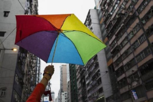 A participant holds a rainbow umbrella as he attends a lesbian, gay, bisexual and transgender (LGBT) Pride Parade in Hong Kong. <br/>Reuters/Tyrone Siu