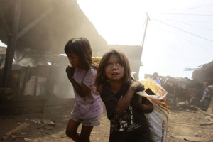 Girls carry sacks in a charcoal factory at a slum in Manila April 12, 2011. <br/>Reuters/Erik de Castro