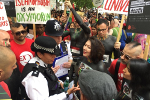 Rights campaigner Maryam Namazie is confronted by police at Gay Pride for the 'Allah is Gay' placards carried by her group. <br/>AP Photo