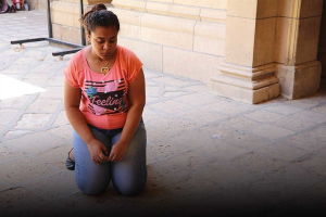Marian kneels by the spot where her father took his final breath. <br/>Open Doors USA
