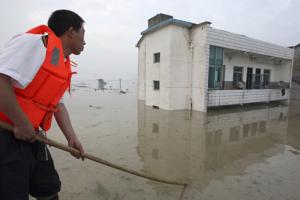 A rescuer evacuates a stranded resident at a flooded village in Zhuji city, Zhejiang Province June 16, 2011. Pelting rain in parts of central and southern China has forced hundreds of thousands of people to leave their homes. <br/>Reuters/China Daily