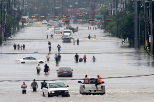 People waded through floodwaters in Houston on Sunday.  <br/>Thomas B. Shea/Agence France-Presse — Getty Images