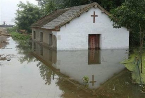 A church is submerged in flood water in Qianmiao village of Fengyang County, east China's Anhui province July 22, 2007. More than 100 people have died in floods and landslides in China, and tens of thousands have fled their homes in the east, where dykes are in danger of being breached by a swollen river. <br/>(Photo/AFP)