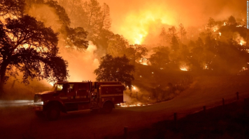 A Cal Fire truck is driven away from flames as the Rocky Fire burns near Clearlake.  <br/>California wildfires
