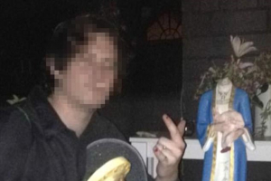 The 19-year-old poses for a picture after breaking the heads off a statue of Mary holding Jesus. <br/>Facebook