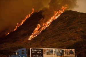 Flames from the Thomas fire burn above a truck on Highway 101 north of Ventura, Calif., on Wednesday, Dec. 6, 2017. <br/>AP Photo