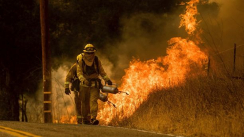 Firefighters light backfire while trying to keep a wildfire from jumping Santa Ana Rd. near Ventura, Calif.  <br/>AP Photo