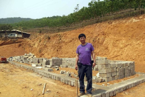 Rev. John Sanqiang Cao breaks a ground on a new school in Wa State, Myanmar. <br/>Ben Cao via AP 