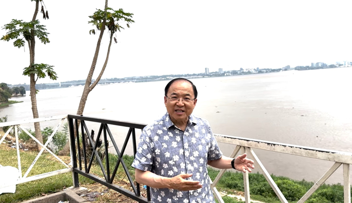 Pastor Tong Liu sharing mission progress in the DRC on the banks of the Congo River (screenshot from the ROLCC YouTube channel)