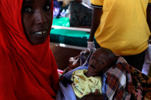 Asiah Dagane Hussein, a refugee from Somalia holds Minhaj Gedi Farahi, her severely malnourished seven-month-old child inside the stabilization ward in the International Rescue Committee, (IRC) field clinic at the Hagadera refugee camp in Dadaab, near the Kenya-Somalia border, July 30, 2011. Minhaj was admitted to the hospital with severe pneumonia, acute severe malnutrition and diarrhoea but has since showed remarkable improvement and now weighs 3.4kg (7 pounds, 8 ounces) and has started breastfeeding according to the IRC doctors. <br/>Reuters / Thomas Mukoya