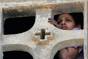 A Christian boy looks from inside the Saint Mary Church, which was set on fire during clashes between Muslims and Christians on Saturday in the heavily populated area of Imbaba in Cairo May 8, 2011. <br/>Reuters / Mohamed Abd El-Ghany