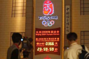 Journalists look at the 2008 Beijing Olympic one-year countdown clock near Tiananmen Square in Beijing August 7, 2007. Preparations for next year's Beijing Olympics are on track, organisers said, shrugging off concerns about food safety, pollution and accusations it has not lived up to its media freedom pledge. <br/>Photo: REUTERS/Jason Lee (CHINA) 