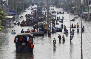 People are evacuated on trucks from a flooded area in Bangkok's suburbs. <br/>Reuters